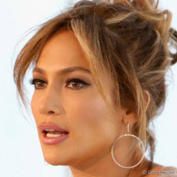 Jennifer Lopez foi ao evento de uma marca com batom nude rosado nos lábios e um clássico traço gatinho de delineador preto nos olhos
